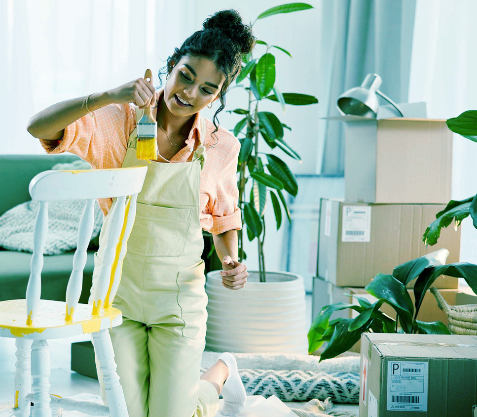 girl paingint a chair a moving boxes picture